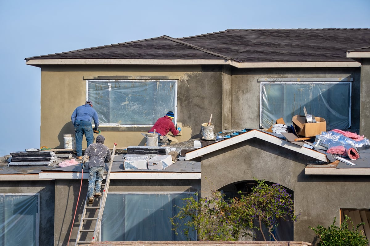 Santa Clara, CA, USA - November 13, 2019: Construction workers plaster the façade of the house.