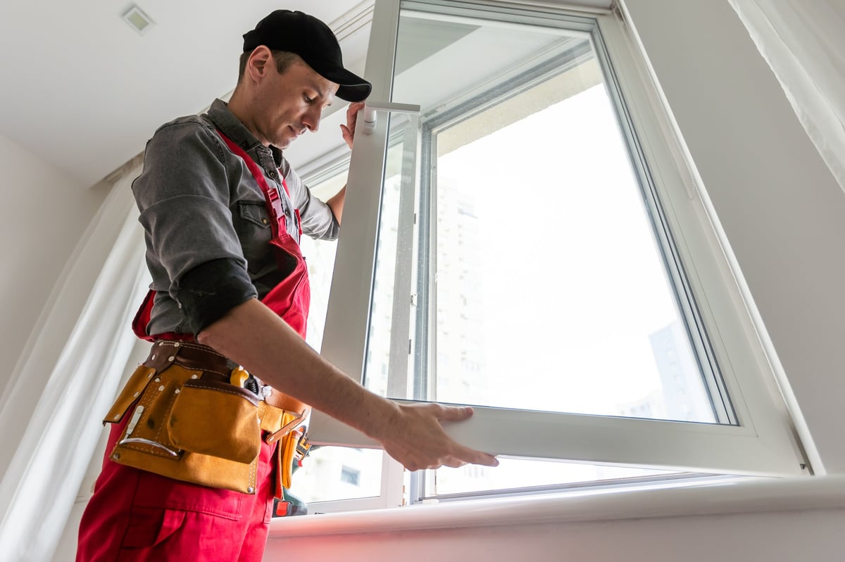 Cheerful young man mounting a kitchen window. High quality photo