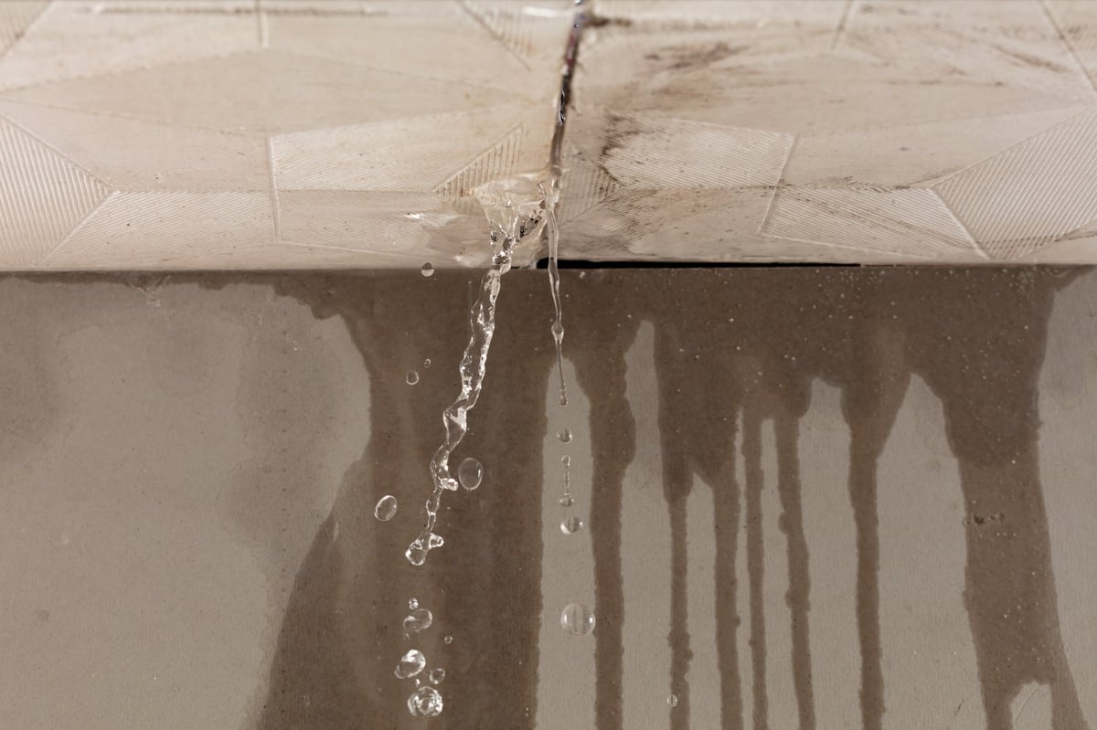 Water leaking from ceiling with stains on wall