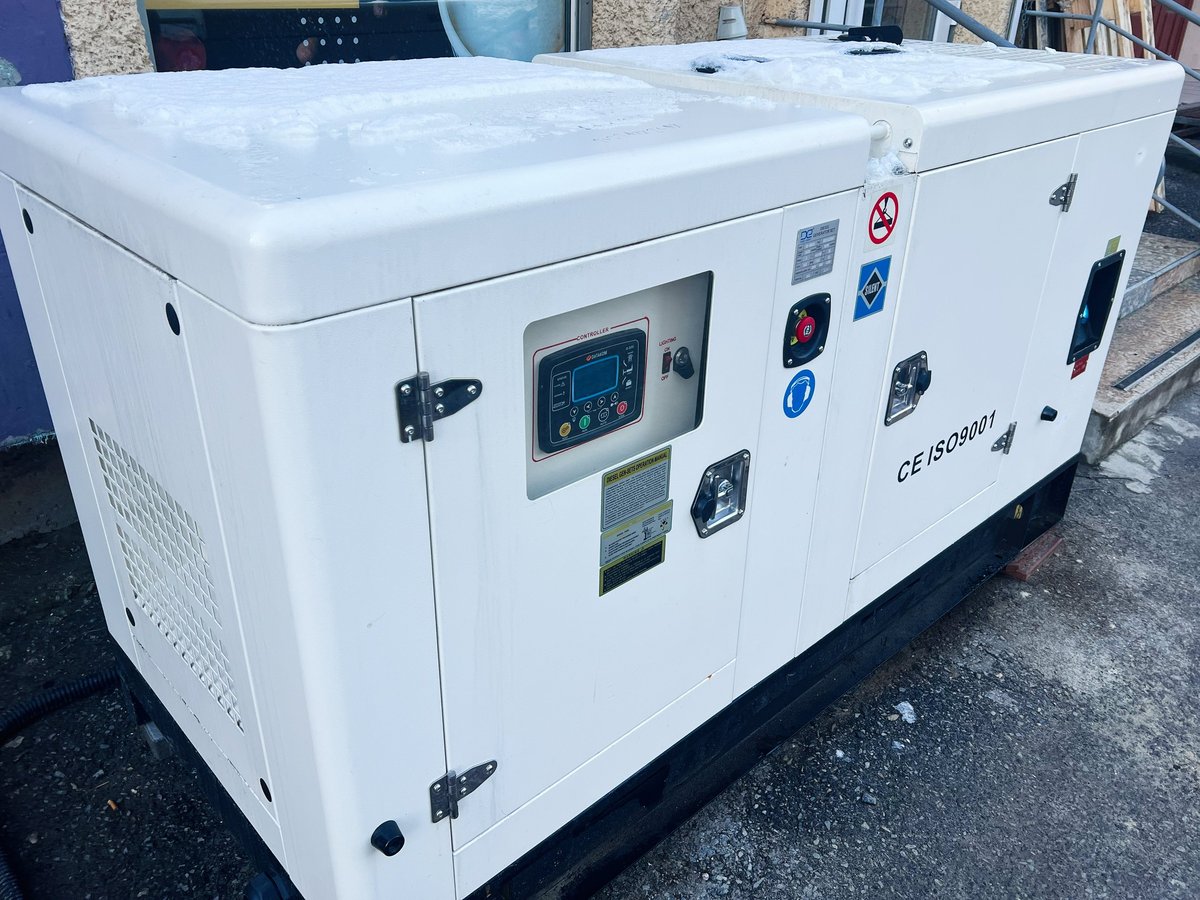 Kyiv, Ukraine - January 11, 2025: A modern white generator unit situated outside in a winter setting. The equipment features functional controls and safety labels, highlighting its heavy-duty and industrial application in energy supply.