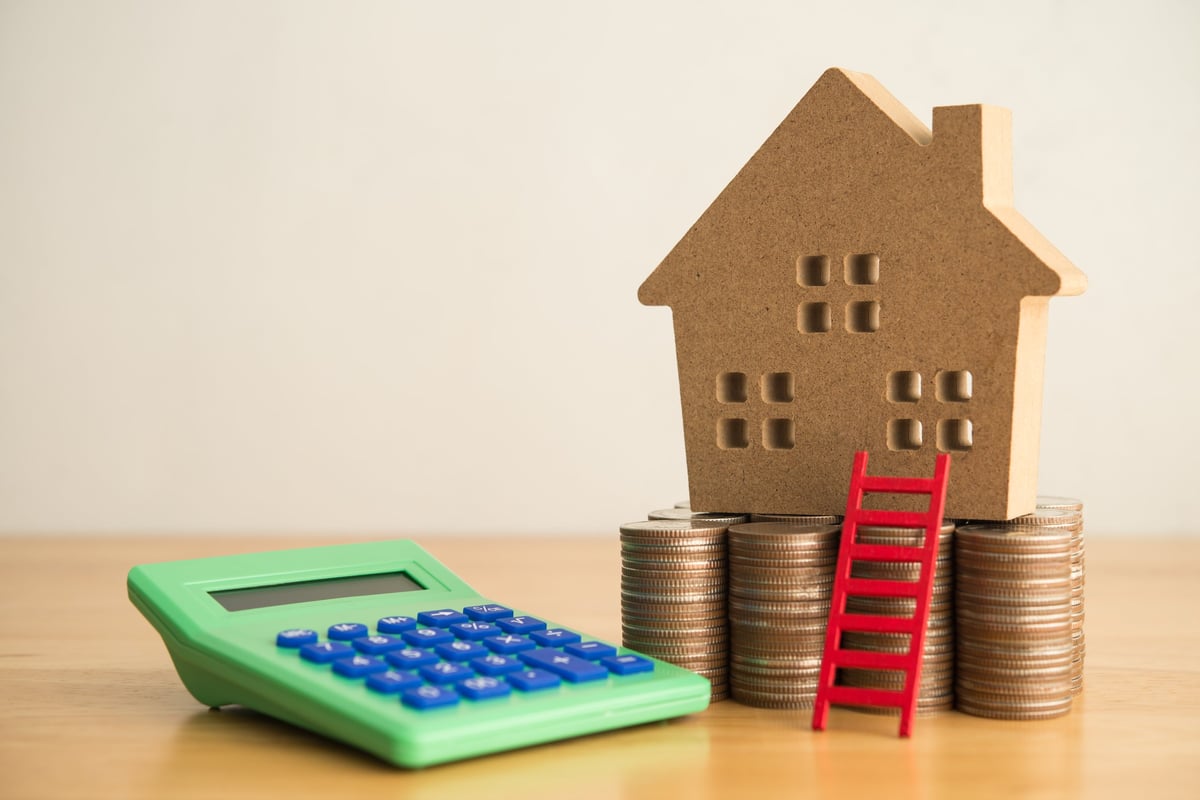 House model, red ladder, stack coins and calculator - home finance and renovation budget planning