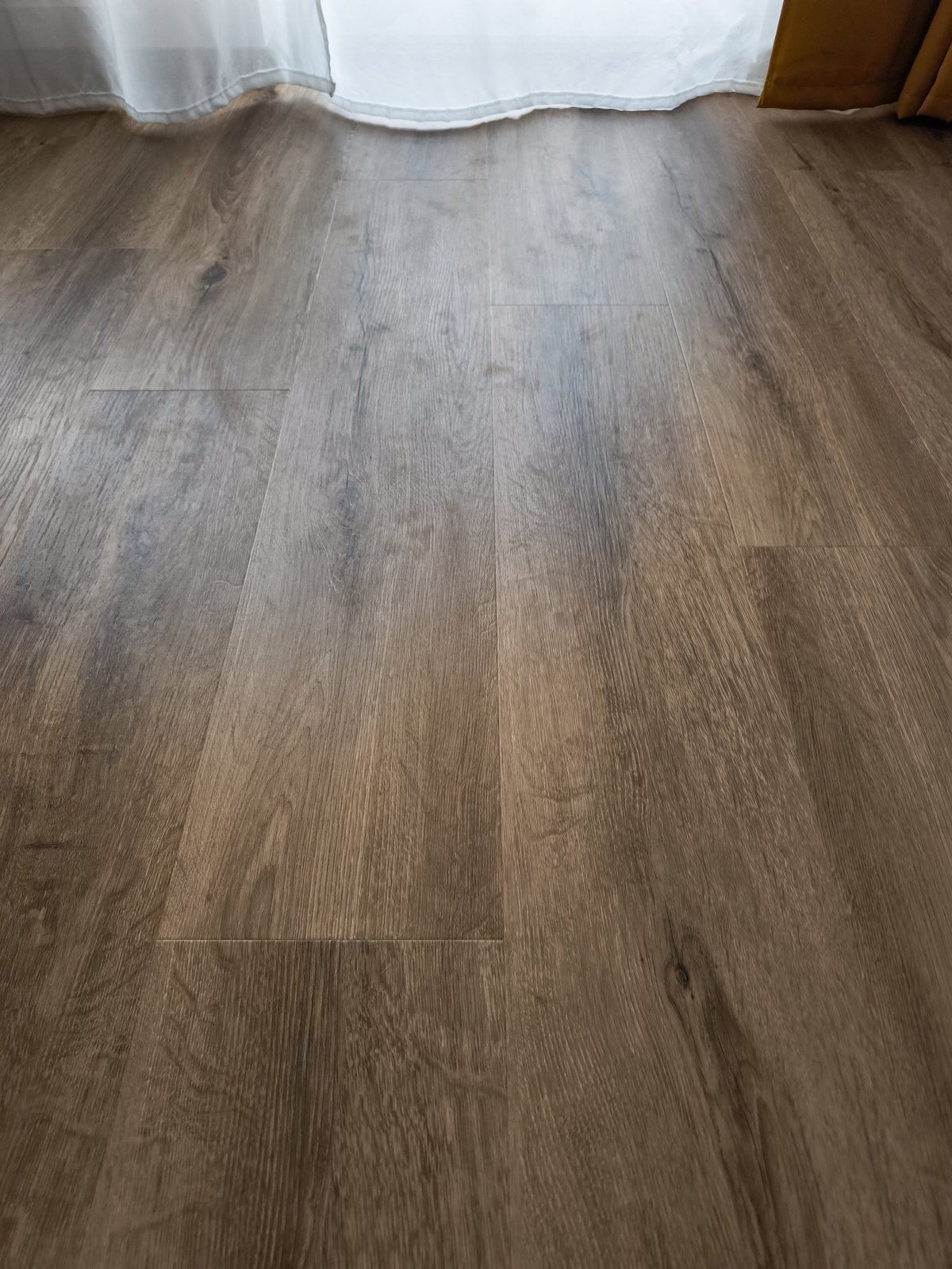 Sunlight gently touches a beautiful dark dirty vinyl floor, creating a warm and inviting atmosphere in a room decorated for spring