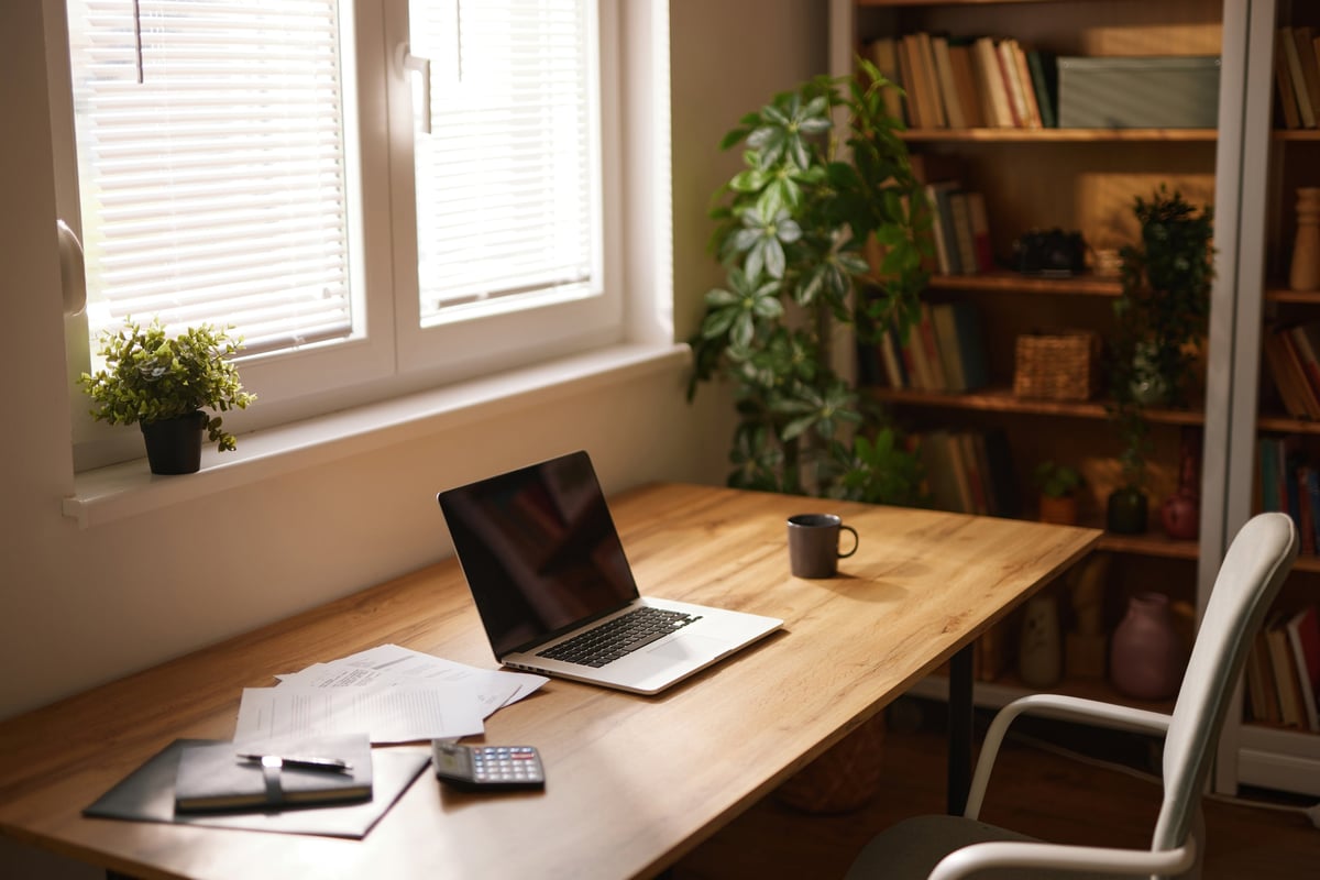 Cozy converted home office with laptop, documents, and a cup of coffee