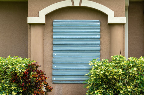 Residential house in Florida with reinforced storm shutters for hurricane protection. Window covering as disaster preparedness.