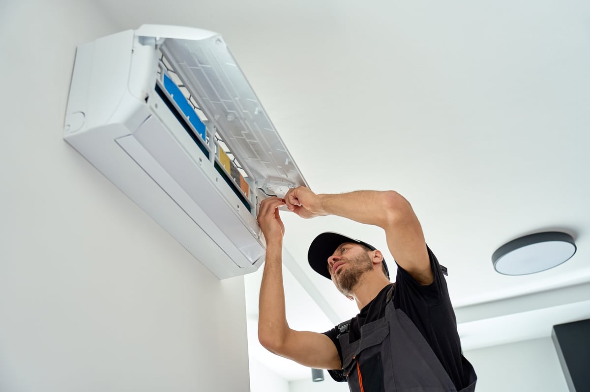Technician works on an open wall air conditioner