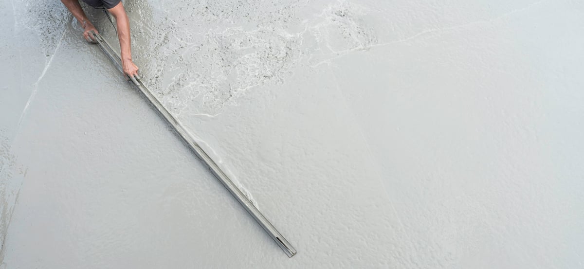 Hand plasterer plastering wet cement floor, hand worker polish rough wet concrete floor for smooth manual triangular trowel well free space for text with occupations about building construction