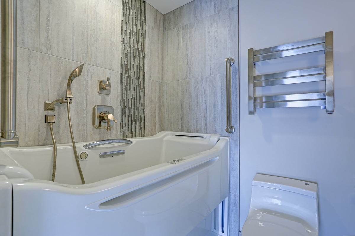 Contemporary bathroom design boasts a luxury hot tub Walk-in Bathtub flanked by subway tiled interior accented with wide glass mosaic tiled vertical stripe
